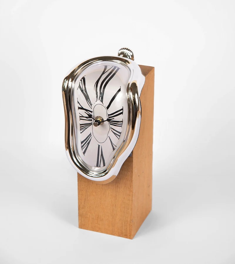 Horloge molle à chiffres romains qui coule sur le bord d'un support en bois