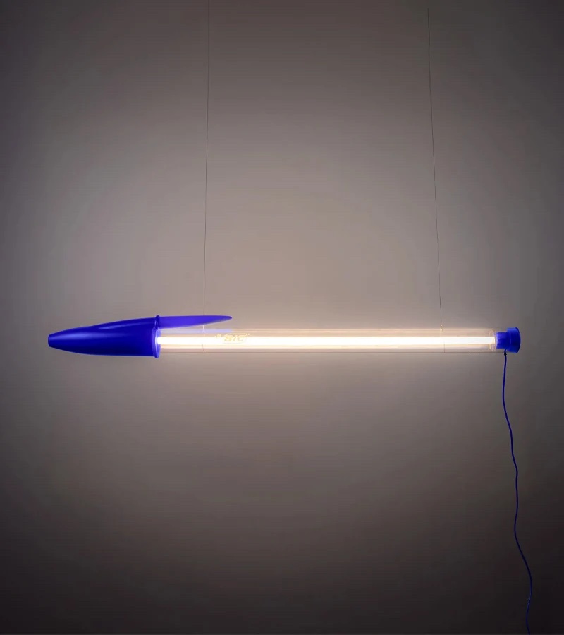 Lampe géante en forme de stylo BIC Cristal allumée et fixée au mur