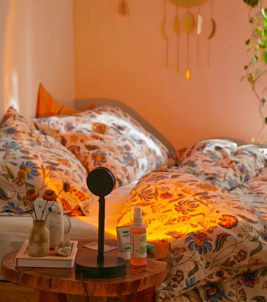 Lampe projetant un halo orangé de coucher de soleil sur un mur