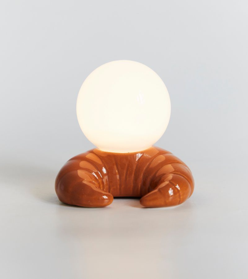 Lampe croissant en céramique surmontée d'un globe en verre allumé