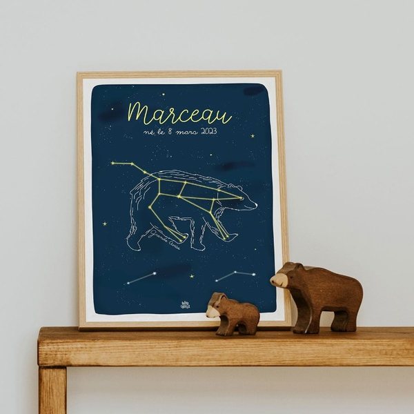 Affiche bleu nuit avec la constellation de la Grande Ourse et le prénom Marceau, posée sur une console en bois