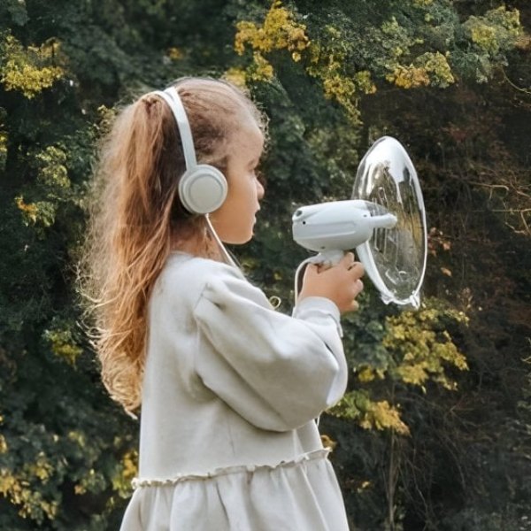 Petite fille avec un casque écoutant la nature grâce à l'amplificateur de son Kidyspy