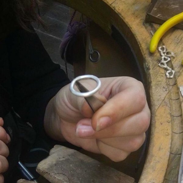 Anneau en argent tenu à la pince pendant la fabrication d'une alliance à Marseille