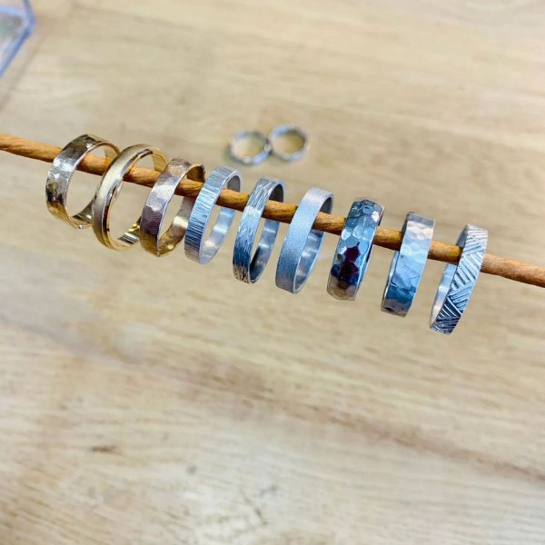 Anneaux d'alliances en argent en cours de fabrication sur une tige dans l'atelier d'Estelle à Paris