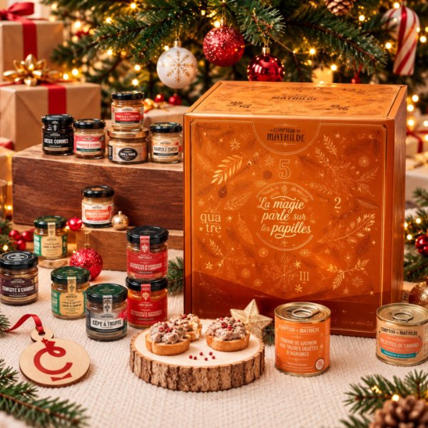 Calendrier de l'Avent Gourmet sucré salé Le Comptoir de Mathilde, coffret orangé posé au pied d'un sapin entre pots et terrines