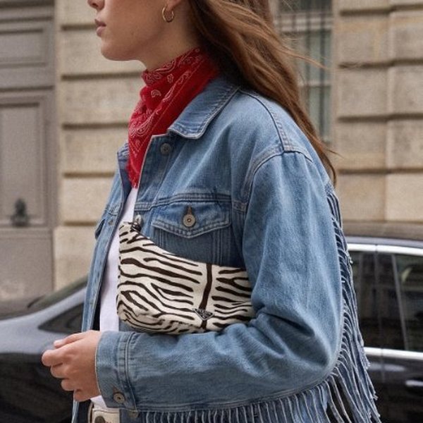 Femme en veste en jean à franges et foulard rouge marchant dans une rue de Paris