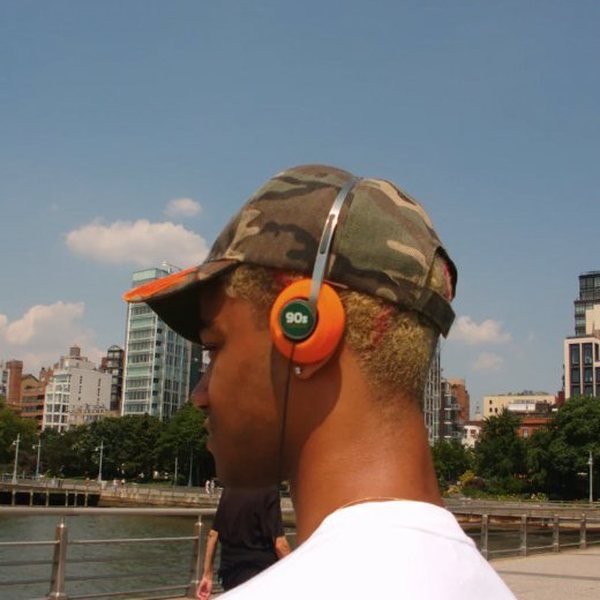 Jeune homme de dos portant un casque rétro à coussinets orange en ville