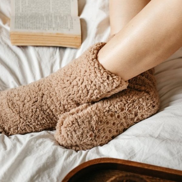 Pieds en chaussettes pilou douillettes posés sur un plaid