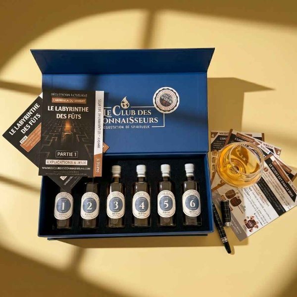 Coffret bleu Le Club des Connaisseurs ouvert sur six flacons de whisky numérotés et un livret