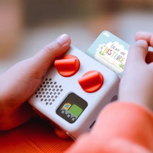 Enfant tenant le raconteur d'histoires Yoto Mini et sa carte audio