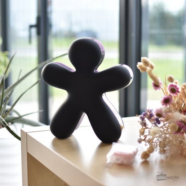 Diffuseur de parfum George noir en forme de bonhomme posé sur une table près d'une fenêtre
