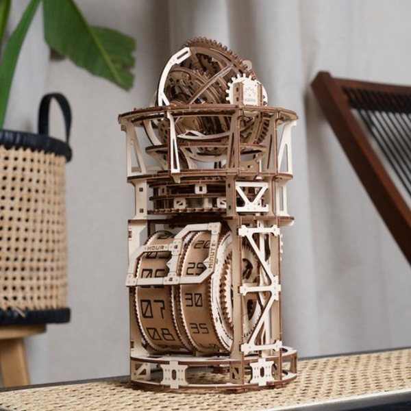 Horloge mécanique en bois à monter Ugears avec tourbillon, posée sur une étagère