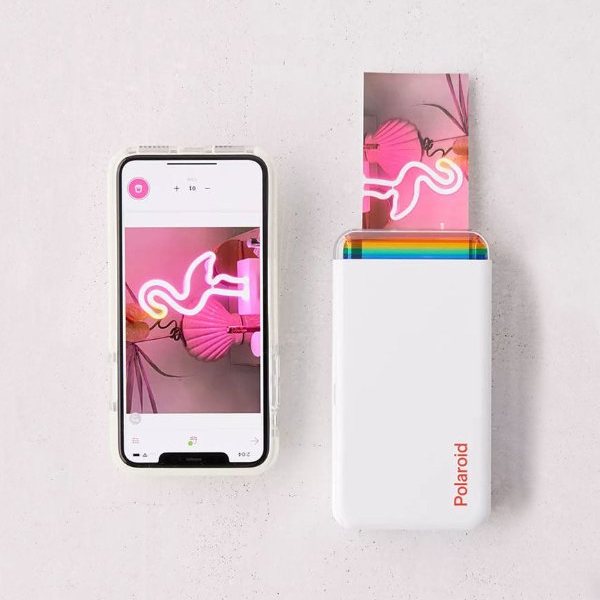 Imprimante Polaroid Hi-Print blanche sortant une photo à côté d'un smartphone