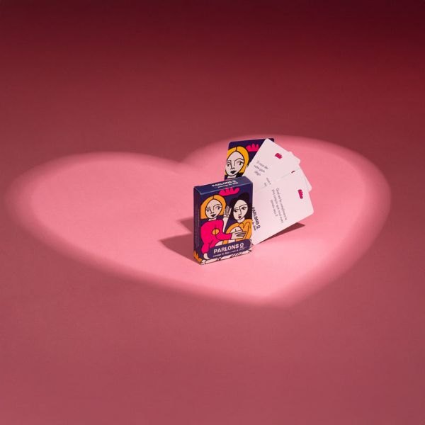 Paquet de cartes Parlons Q illustré posé dans un halo de lumière en forme de cœur