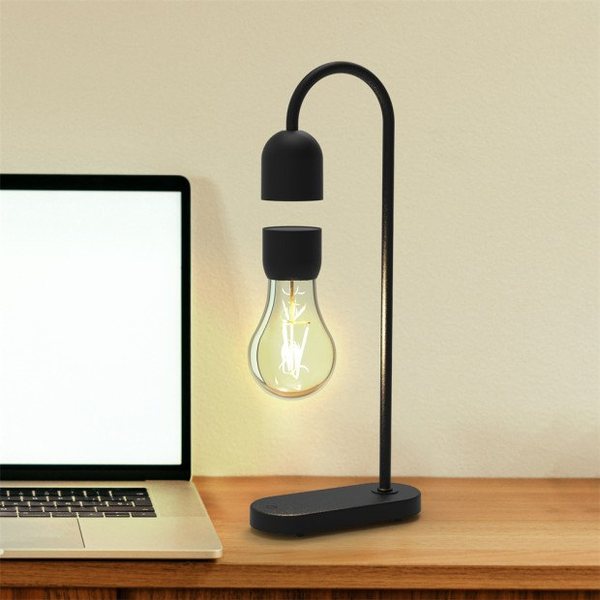 Lampe HaloFloat avec ampoule LED allumée en lévitation sous une potence noire, posée sur un bureau