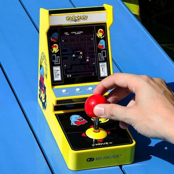 Mini borne d'arcade Pac-Man jaune avec joystick rouge manipulé par une main