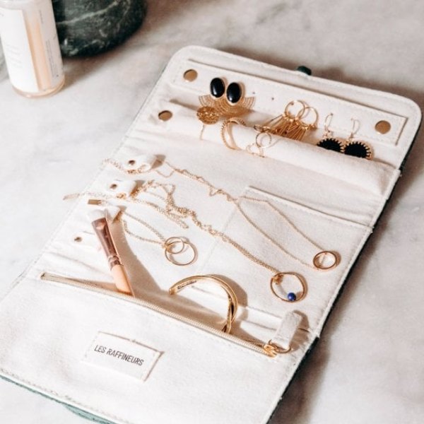 Pochette à bijoux en velours ouverte sur ses colliers et boucles d'oreilles