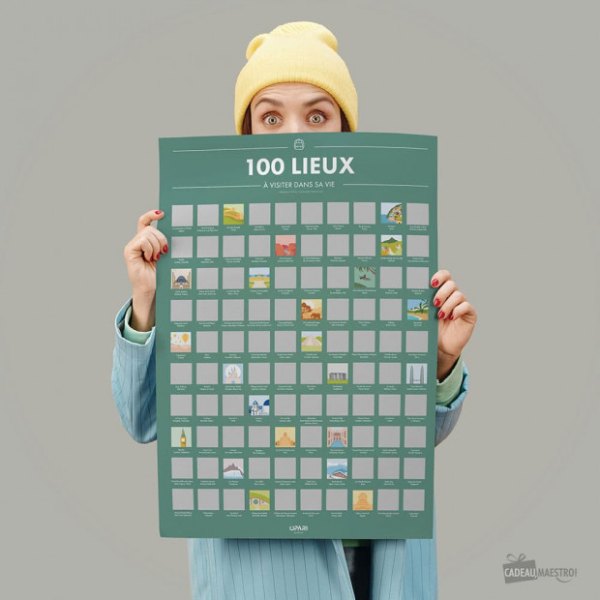 Poster à gratter des 100 lieux à visiter dans sa vie tenu par une voyageuse