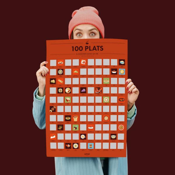 Poster à gratter 100 plats à goûter dans sa vie, tenu devant un mur