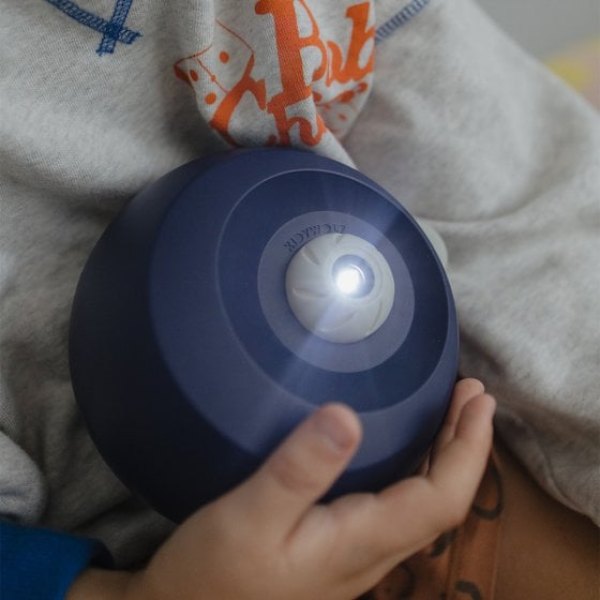Enfant tenant le projecteur galaxie Kidystar allumé