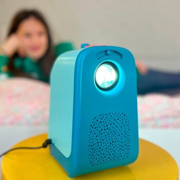 Projecteur d'histoires Tikino bleu posé sur un lit d'enfant