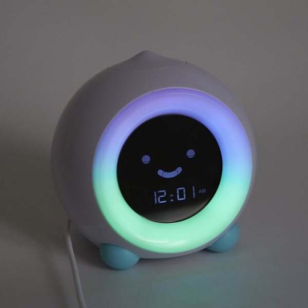 Réveil enfant Mella gris avec un visage souriant et un halo lumineux bleu et vert