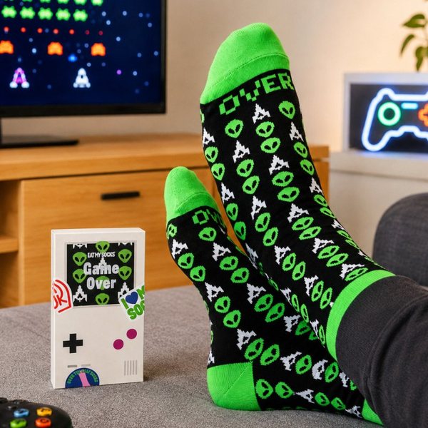 Pieds en chaussettes noires et vertes motif Game Over devant un écran de jeu vidéo rétro