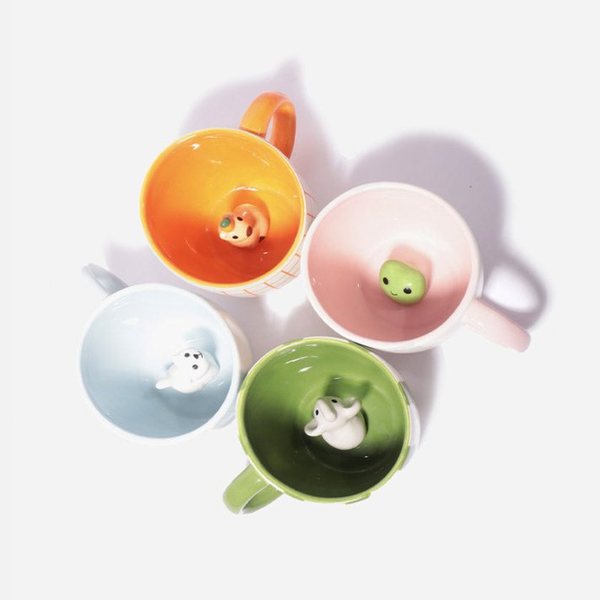 Quatre mugs en céramique avec une grenouille, un chat, un capybara et un éléphant cachés au fond